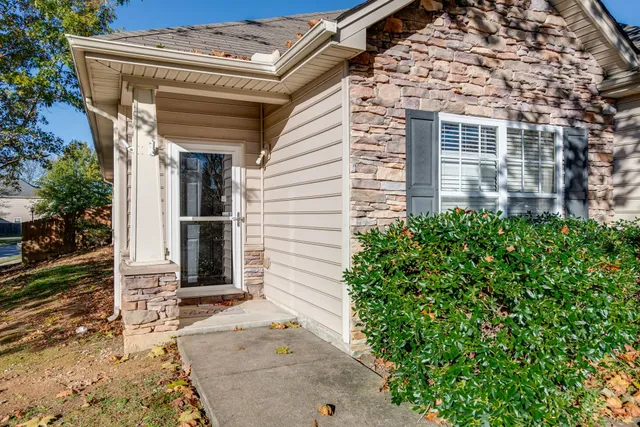 front view of a house with a large window and potted plants