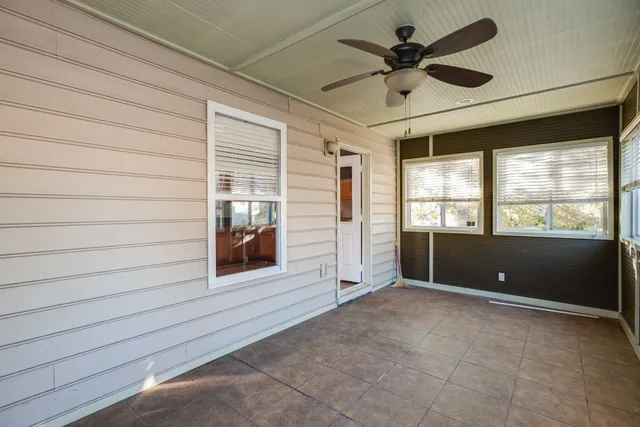 a view of an empty room with a window and a ceiling fan