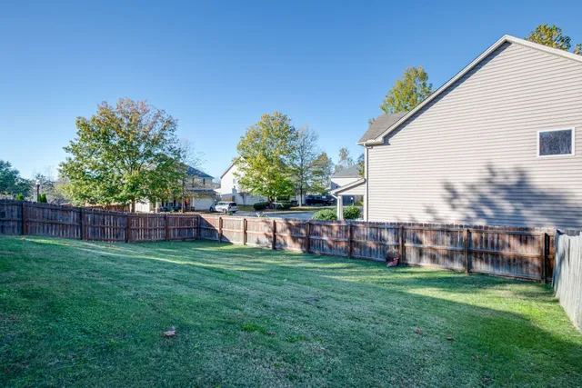 a view of yard with green space and wooden fence
