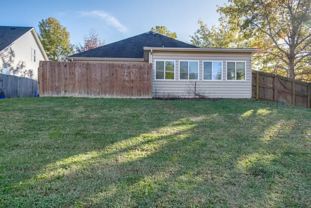 a backyard of a house with wooden floor and fence