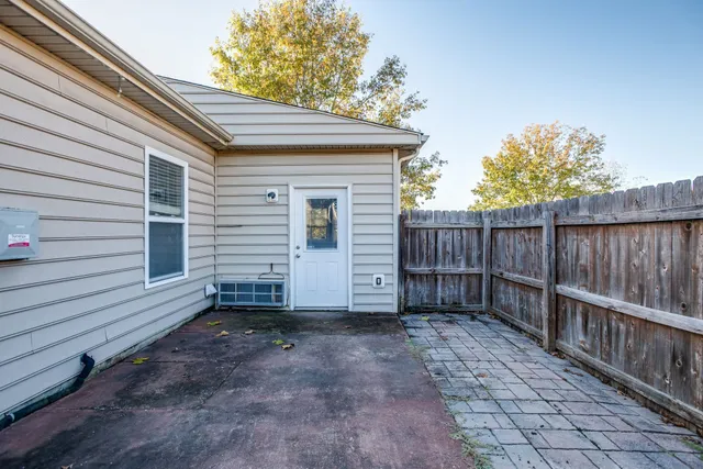a view of a house with a small yard and wooden fence