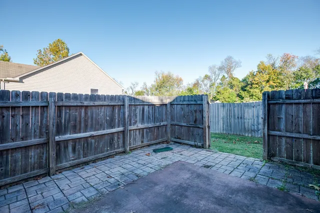a view of a backyard with wooden fence