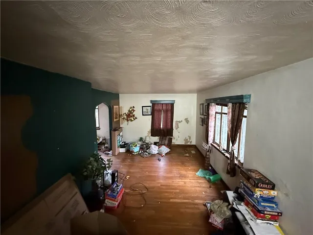 a living room with furniture hard wood floor and next to a window