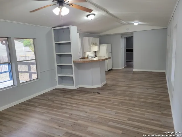 a view of a kitchen with wooden floor and a window