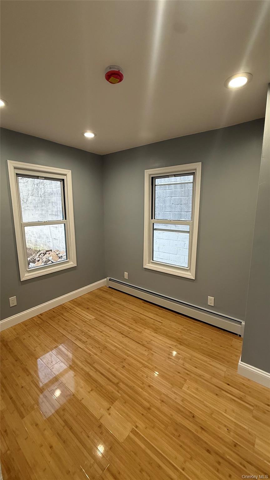 116-45 195th Street Queens, NY 11412 - Photo 11 of 21 a view of an empty room with wooden floor and a window