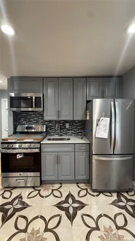 a kitchen with kitchen island wooden cabinets and stainless steel appliances