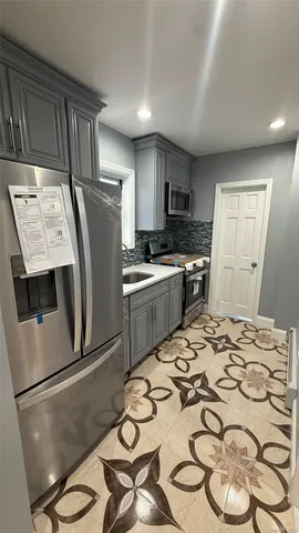 a kitchen with stainless steel appliances a stove a sink and a refrigerator