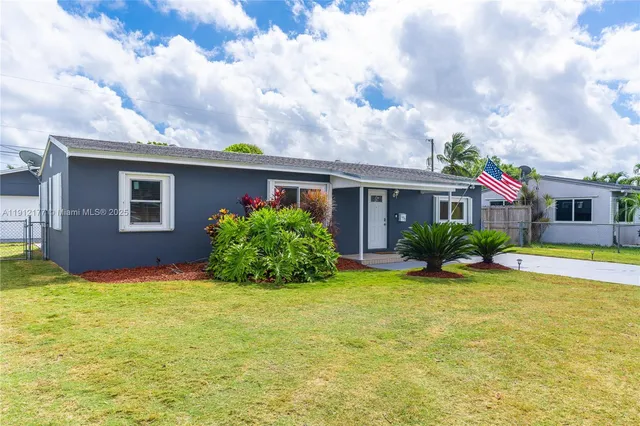 a view of a house with a yard and potted plants
