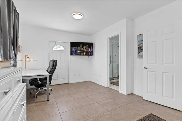 a view of a workspace with furniture and a window