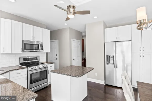 a kitchen with granite countertop wooden cabinets and a counter top space