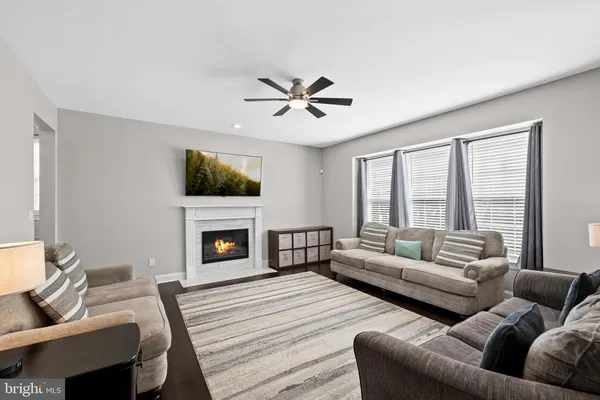 a kitchen with stainless steel appliances granite countertop a refrigerator a sink dishwasher a stove and white cabinets with wooden floor