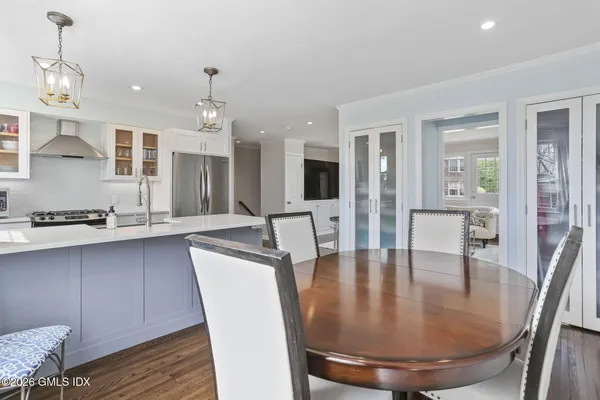 a dining room with wooden floor and chandelier