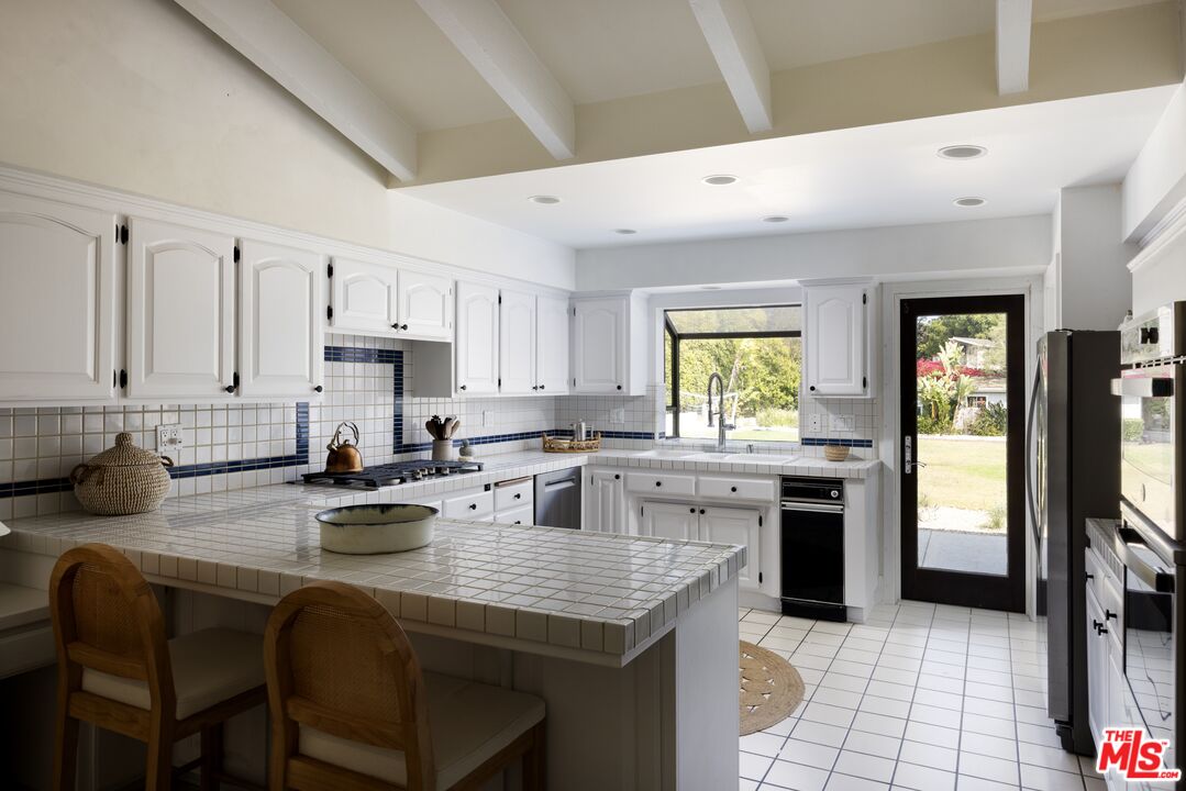 29328 Heathercliff Road Malibu, CA 90265 - Photo 14 of 41 a kitchen with sink a stove and cabinets