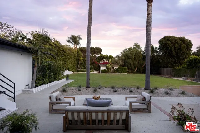 a front view of a house with a garden and yard