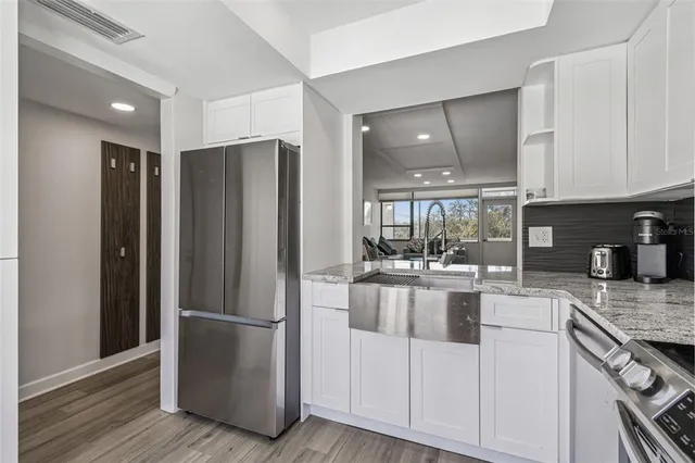 a kitchen with stainless steel appliances granite countertop a stove microwave and sink