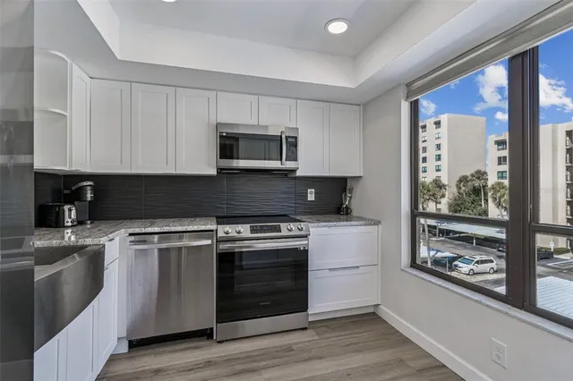 a kitchen with a stove a microwave and wooden floor