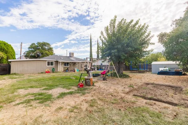 a view of a house with backyard and trees