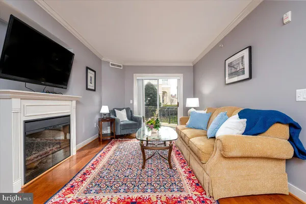 a living room with a couch a flat screen tv and a fireplace