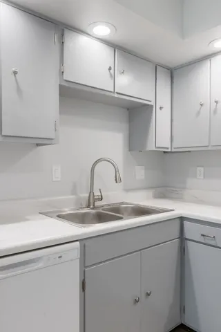 a kitchen with stainless steel appliances granite countertop a sink and a white cabinets