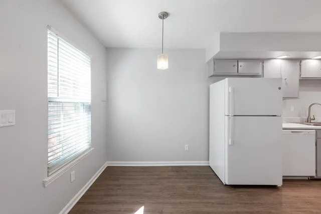 a view of empty room with wooden floor and window