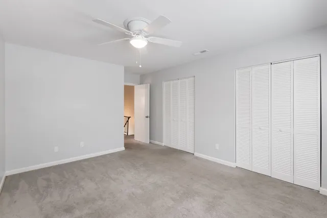 a view of an empty room with a chandelier fan