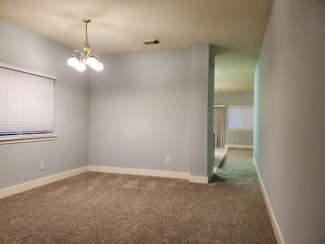 a view of a chandelier in big room with a chandelier fan