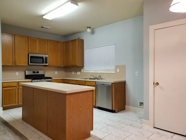 a kitchen with stainless steel appliances granite countertop a stove a sink and a refrigerator