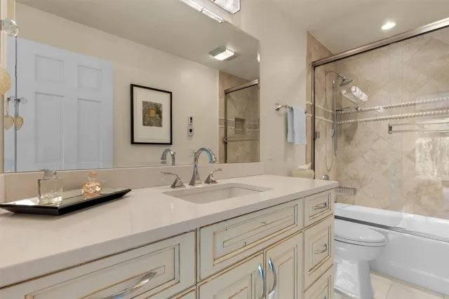 a bathroom with a granite countertop sink a toilet and a mirror