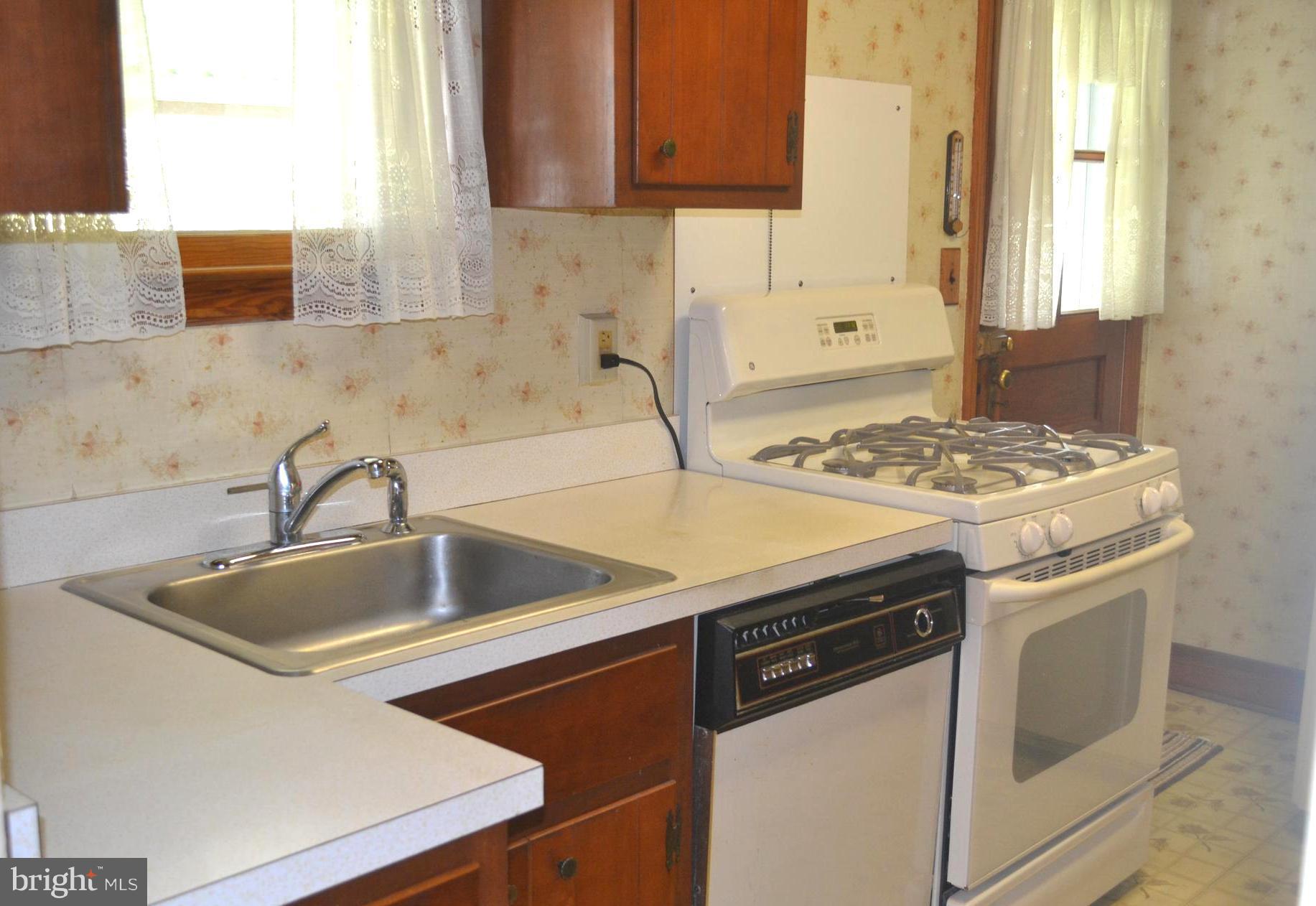 432 Cleveland Road Linthicum Heights, MD 21090 - Photo 3 of 18 a kitchen with granite countertop a sink stove and cabinets