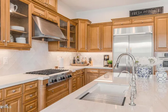 a kitchen with stainless steel appliances granite countertop a sink a stove and microwave