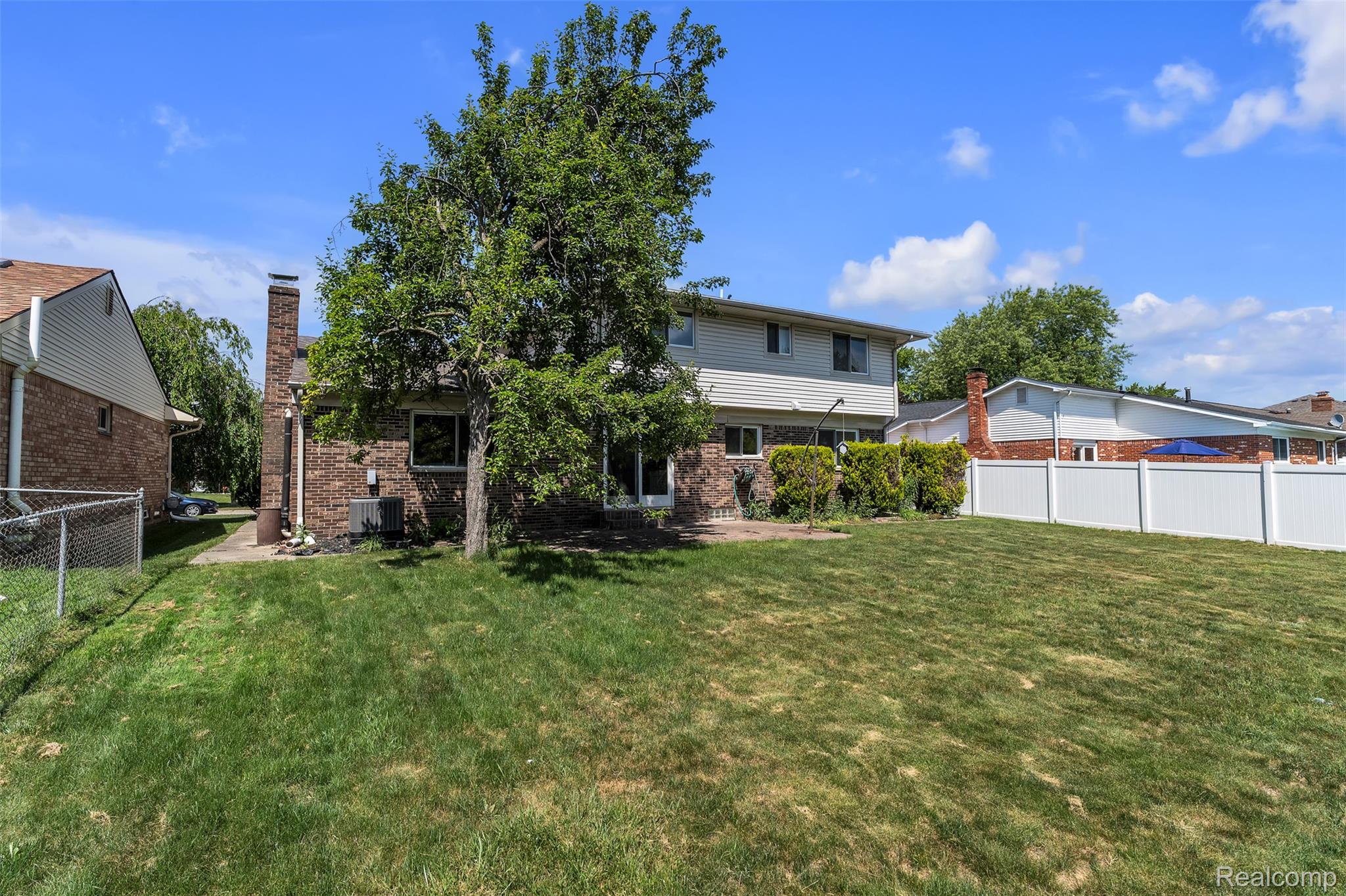7000 Woonsocket Street Canton, MI 48187 - Photo 61 of 65 Expansive backyard featuring a manicured lawn, a large shade tree, and a white privacy fence