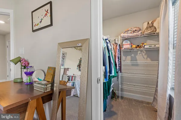 a spacious bedroom with a bed a dresser and a window