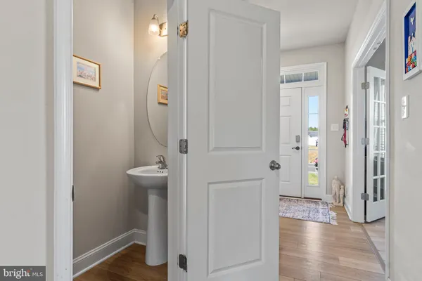 a living room with furniture kitchen view and a wooden floor