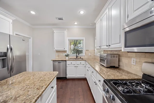 a kitchen with stainless steel appliances granite countertop a stove a sink and a refrigerator