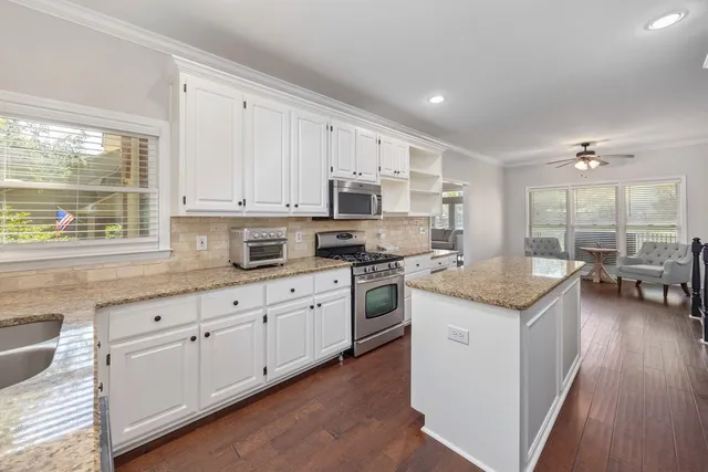 a kitchen with granite countertop white cabinets and white appliances