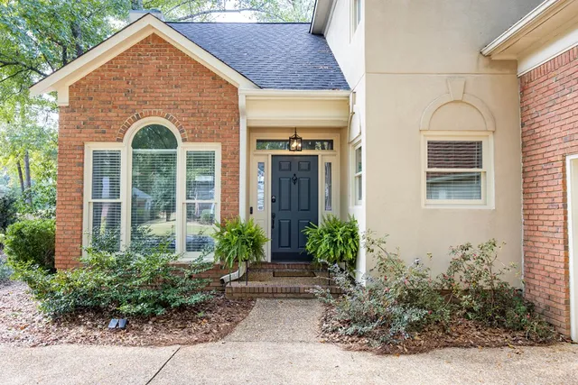 a view of a brick house with potted plants