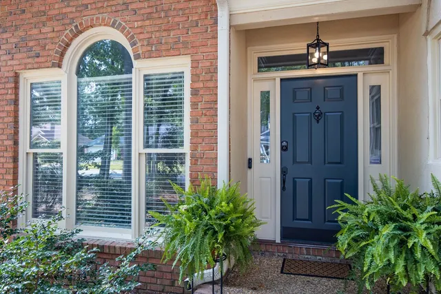 a view of a brick house with plants