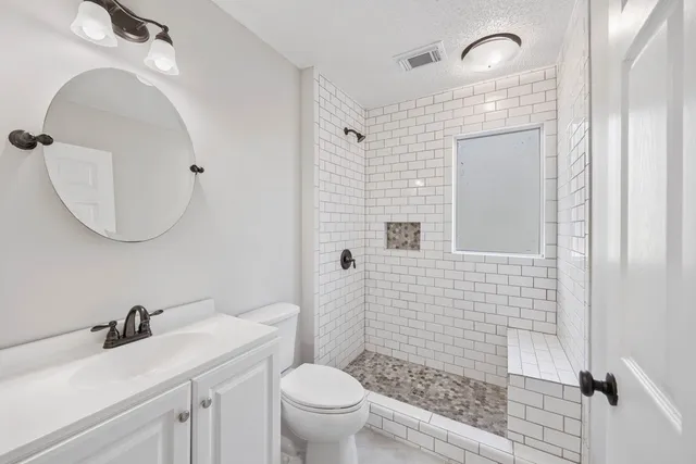 a bathroom with a sink a toilet and shower