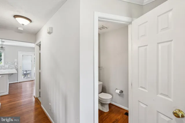 a bathroom view of a toilet and a mirror