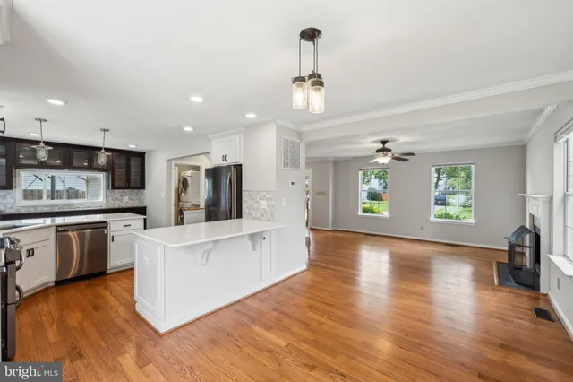 a large kitchen with cabinets wooden floor and stainless steel appliances