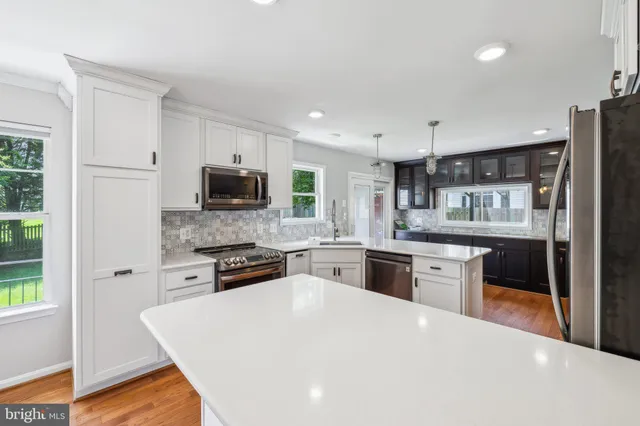 a large kitchen with cabinets stainless steel appliances and a window