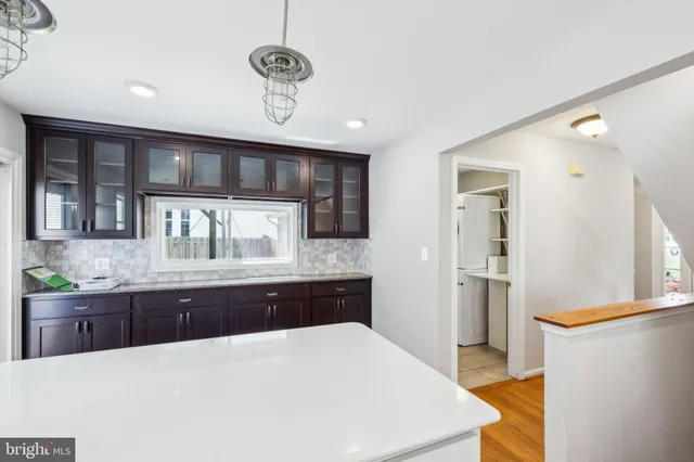 a large kitchen with stainless steel appliances a large counter top a stove and a refrigerator