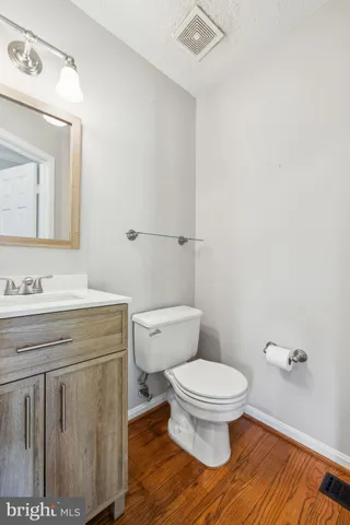 a bathroom with a granite countertop toilet a sink and a mirror