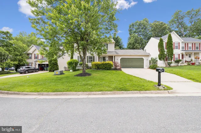 a front view of a house with a yard and trees