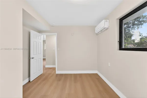 a view of a room with wooden floor and window