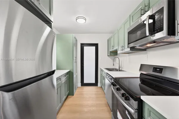 a kitchen with stainless steel appliances granite countertop a stove a sink and a refrigerator