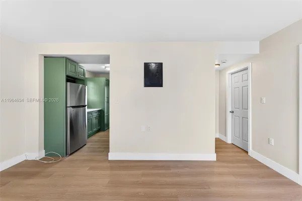 a view of a livingroom with wooden floor and a hallway