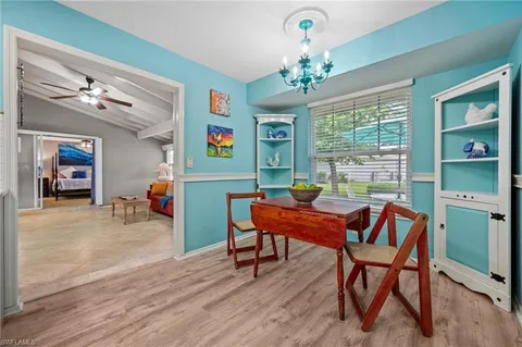 a dining room with furniture a chandelier and wooden floor