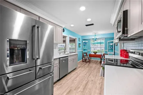 a kitchen with stainless steel appliances granite countertop a refrigerator and a stove