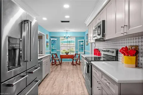 a kitchen with stainless steel appliances granite countertop a refrigerator and a stove